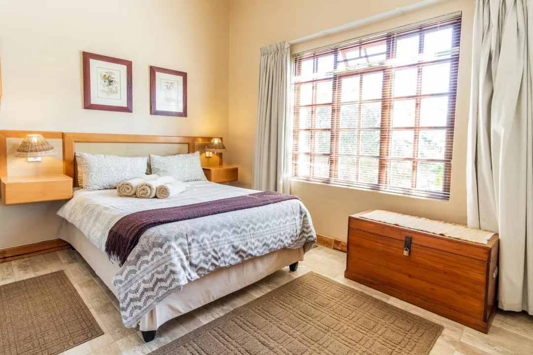 Cozy bedroom with a double bed bedside tables and a large window