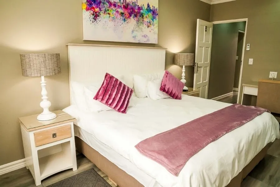 Cozy bedroom with a large bed colorful pillows and bedside lamps