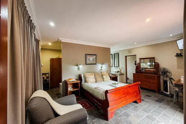 Cozy bedroom with wooden bed armchair and dresser in a welllit room