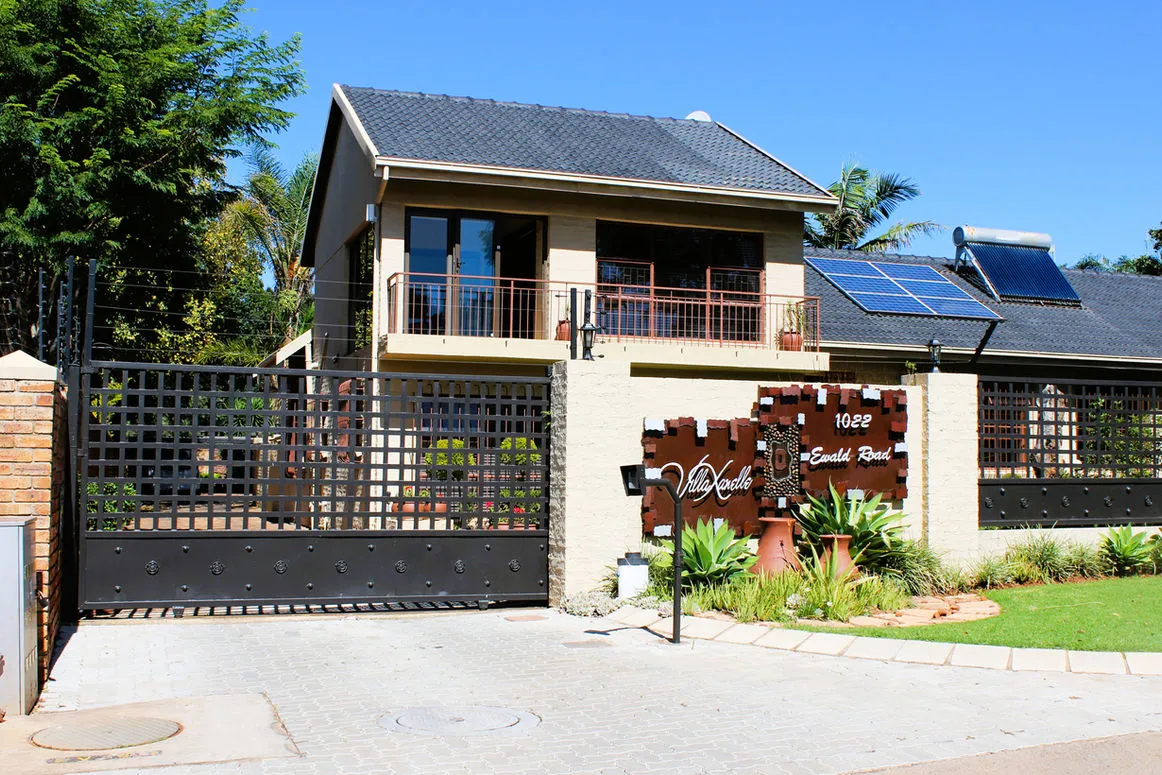 Modern twostory house with solar panels gated entrance and garden