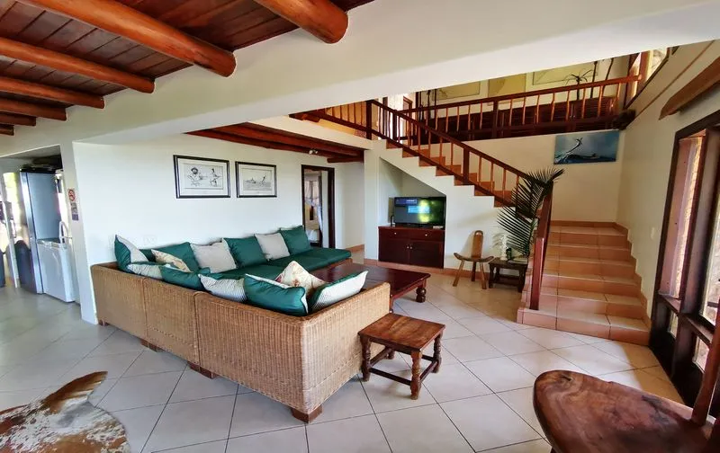 Modern living room with sectional sofa TV and staircase leading to upper level