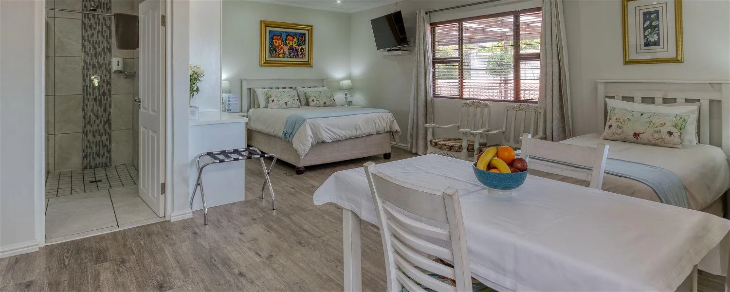 Cozy bedroom with two beds dining table and attached bathroom
