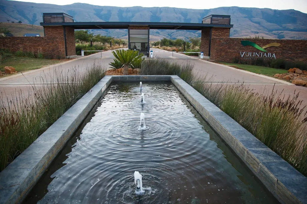 Entrance to Vunlamba with a water feature and mountainous backdrop