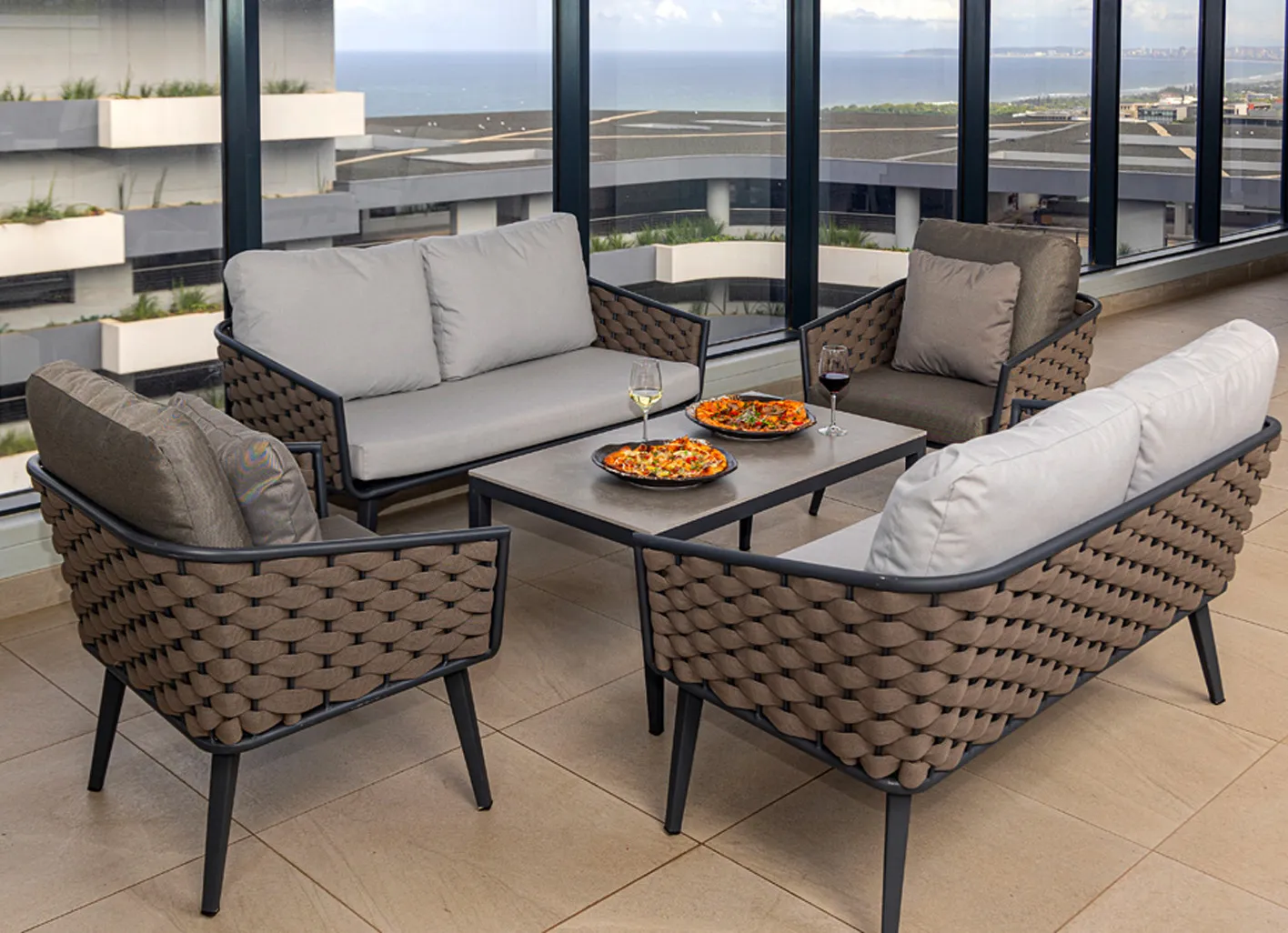 Outdoor lounge set with food and drinks on a table ocean view
