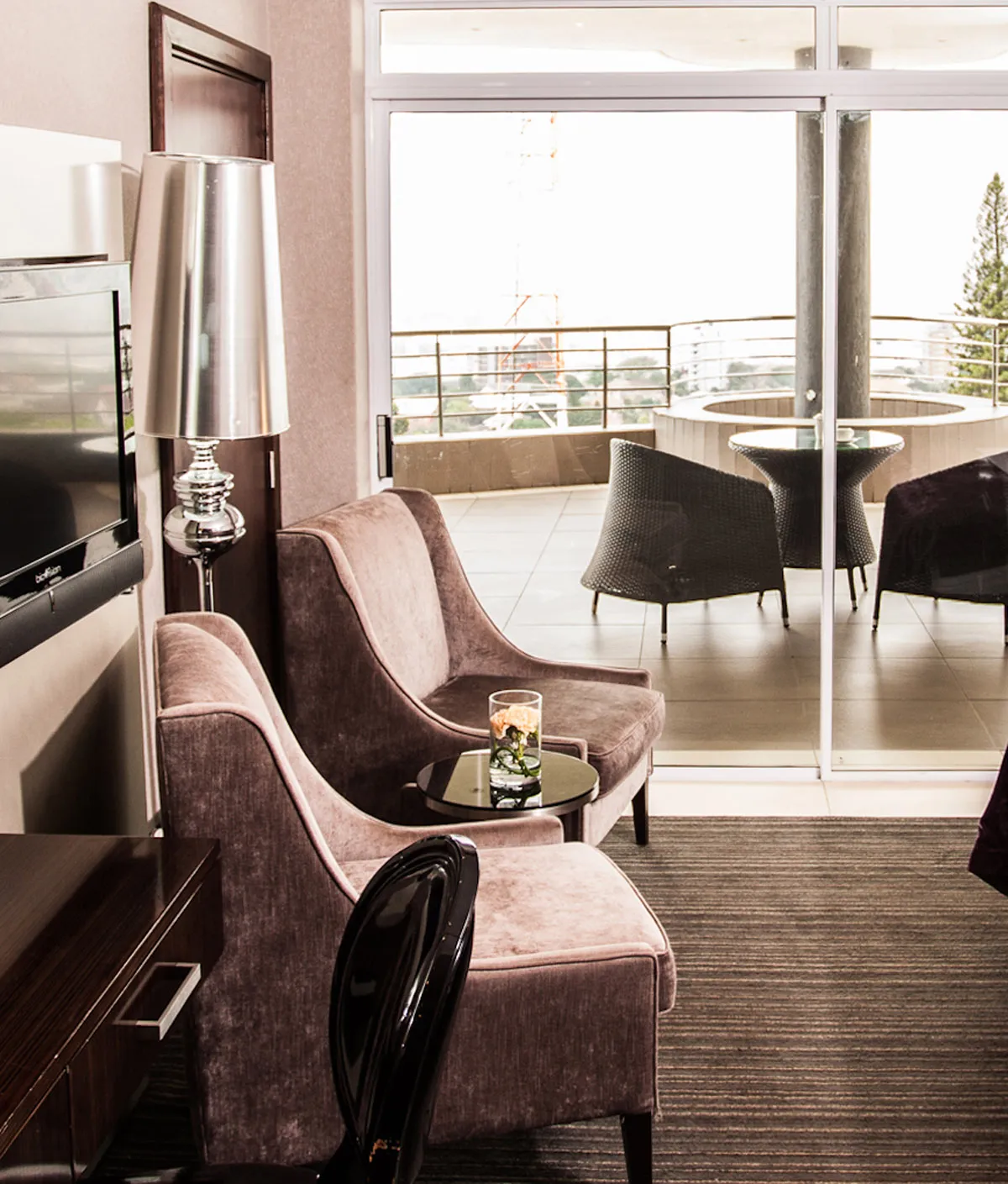 Modern living room with armchairs lamp and view of outdoor seating area