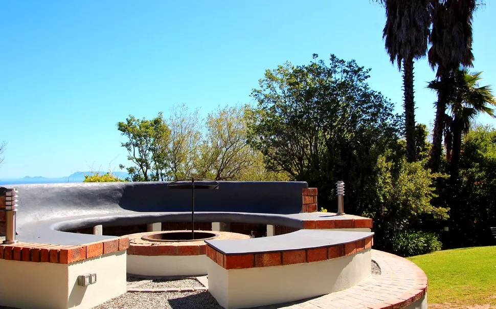 Outdoor seating area with a fire pit surrounded by trees and grass
