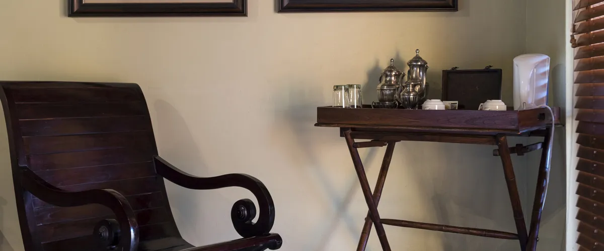 Wooden chair and table with decorative items in a cozy room corner