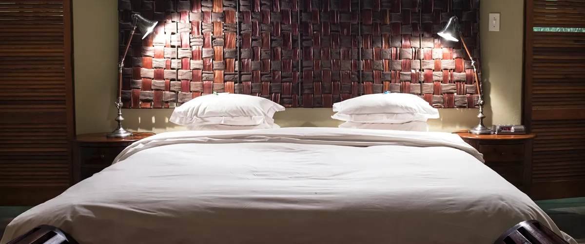 Modern bedroom with a large bed wooden headboard and bedside lamps