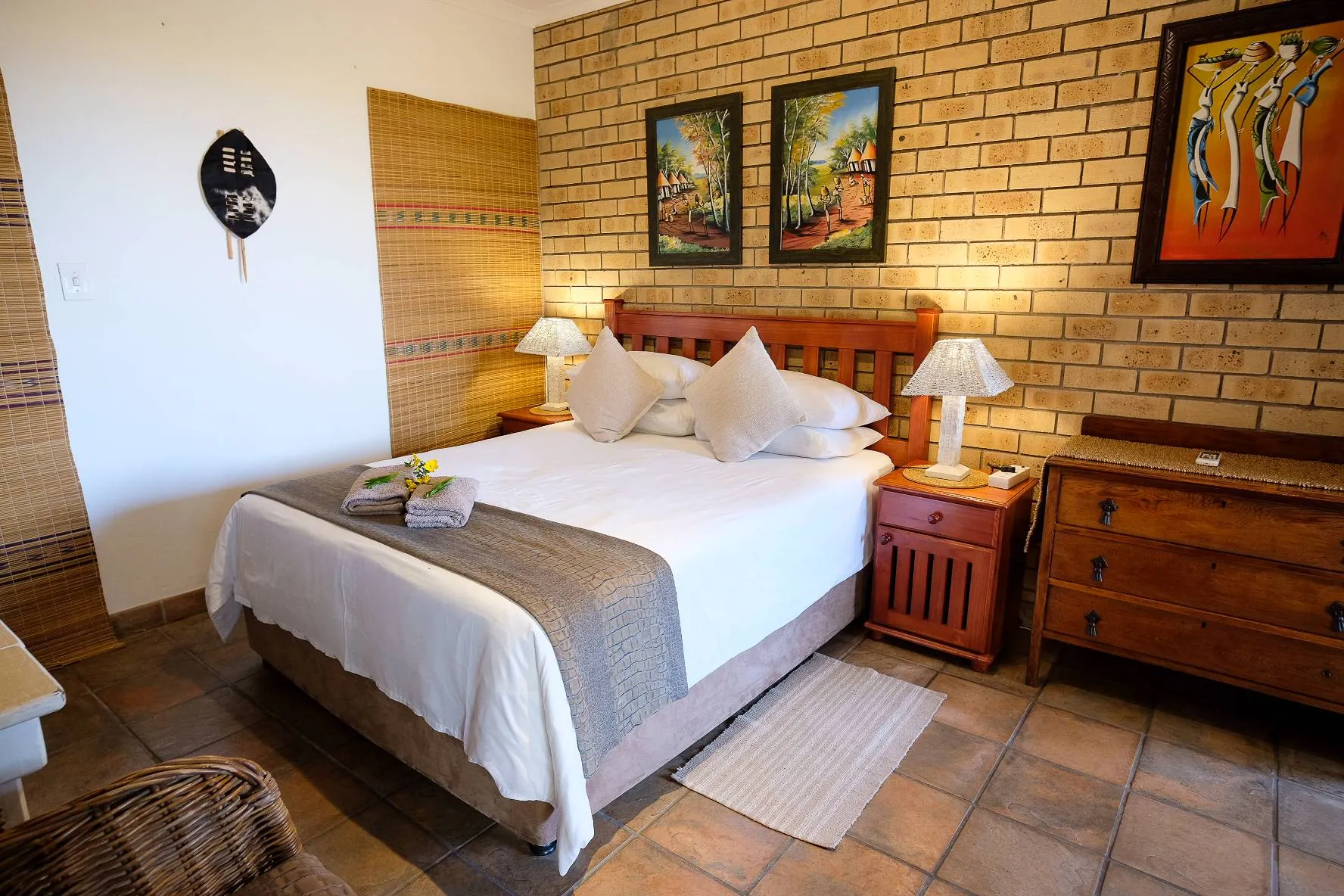 Cozy bedroom with a double bed wooden furniture and brick wall decor