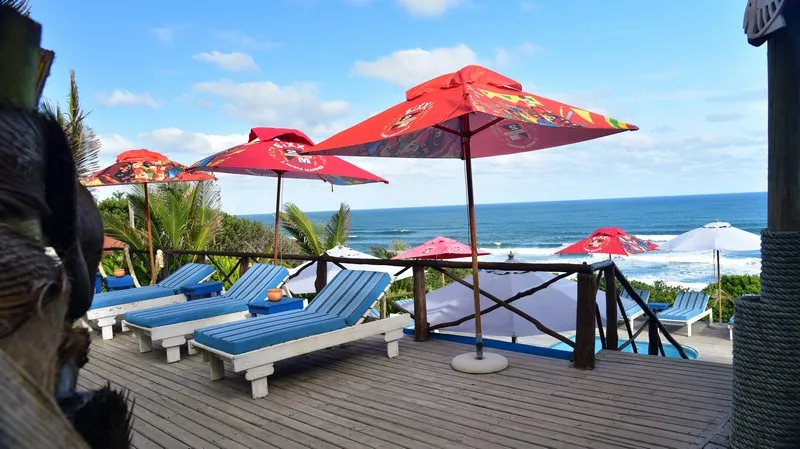 Beachside lounge area with colorful umbrellas blue chairs and ocean view