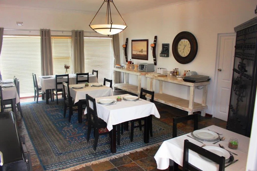 Dining area with tables chairs and a buffet counter in a bright room