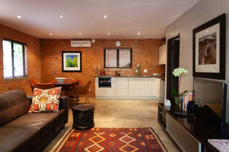 Openplan living area with kitchen dining table sofa and wall art