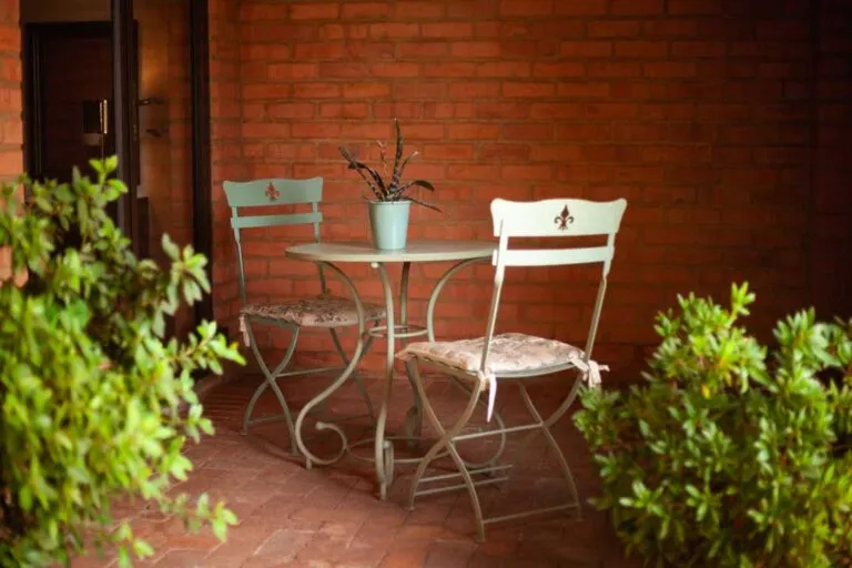 Two chairs and a table with a plant on a brick patio