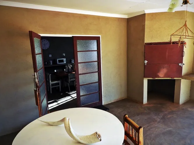 Dining area with open door to kitchen and rustic oven in corner
