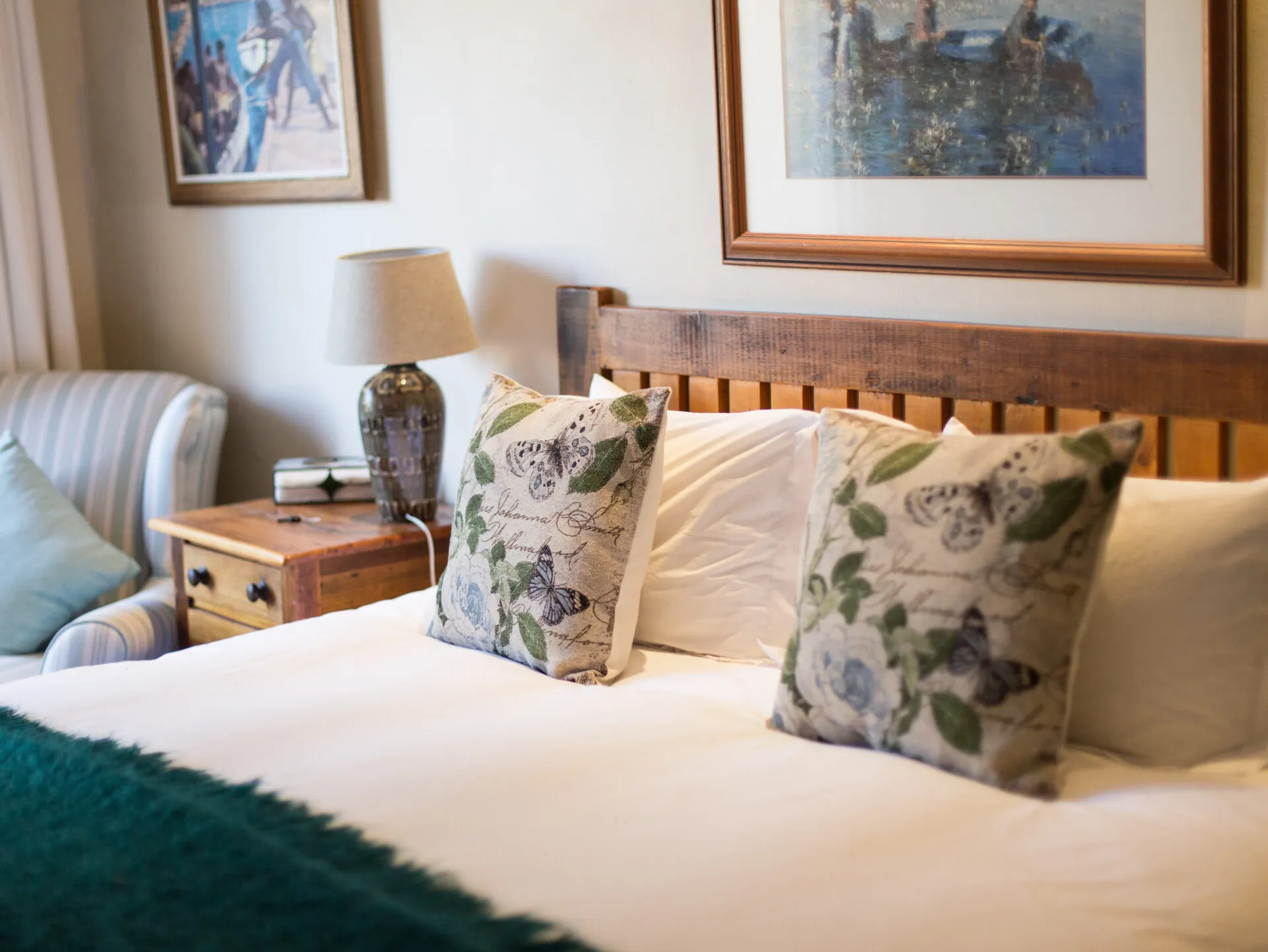 Cozy bedroom with neatly made bed floral pillows and bedside lamp