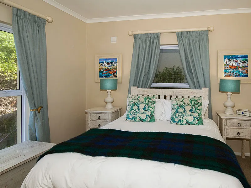 Cozy bedroom with a bed two nightstands lamps and window curtains