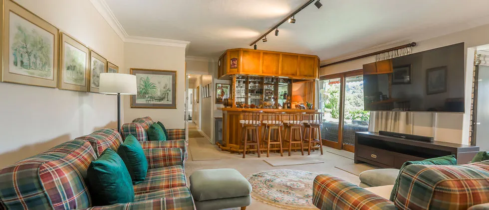 Cozy living room with plaid sofas bar area and large TV