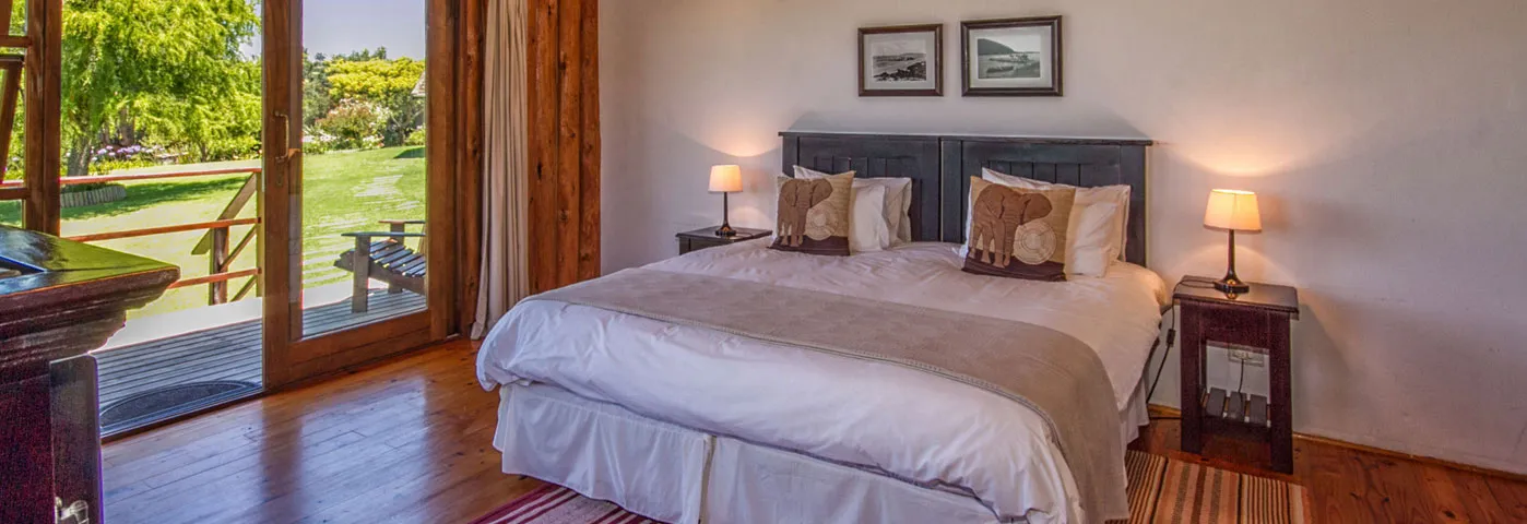 Cozy bedroom with a large bed wooden floor and a garden view