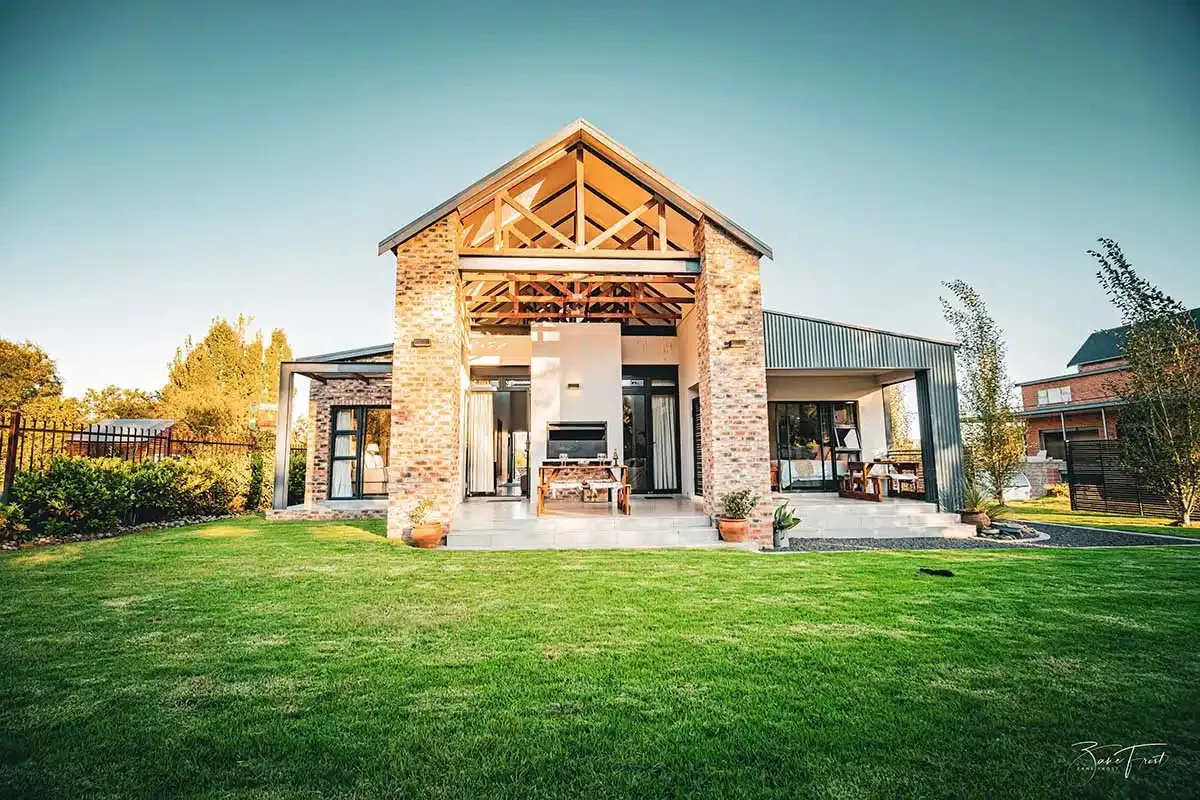 Modern house with large lawn outdoor fireplace and patio furniture