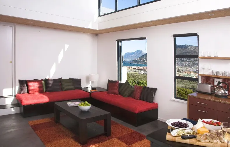 Modern living room with red sofas large windows and mountain view