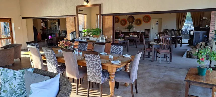 Dining area with wooden tables chairs and decorative plants in a spacious room