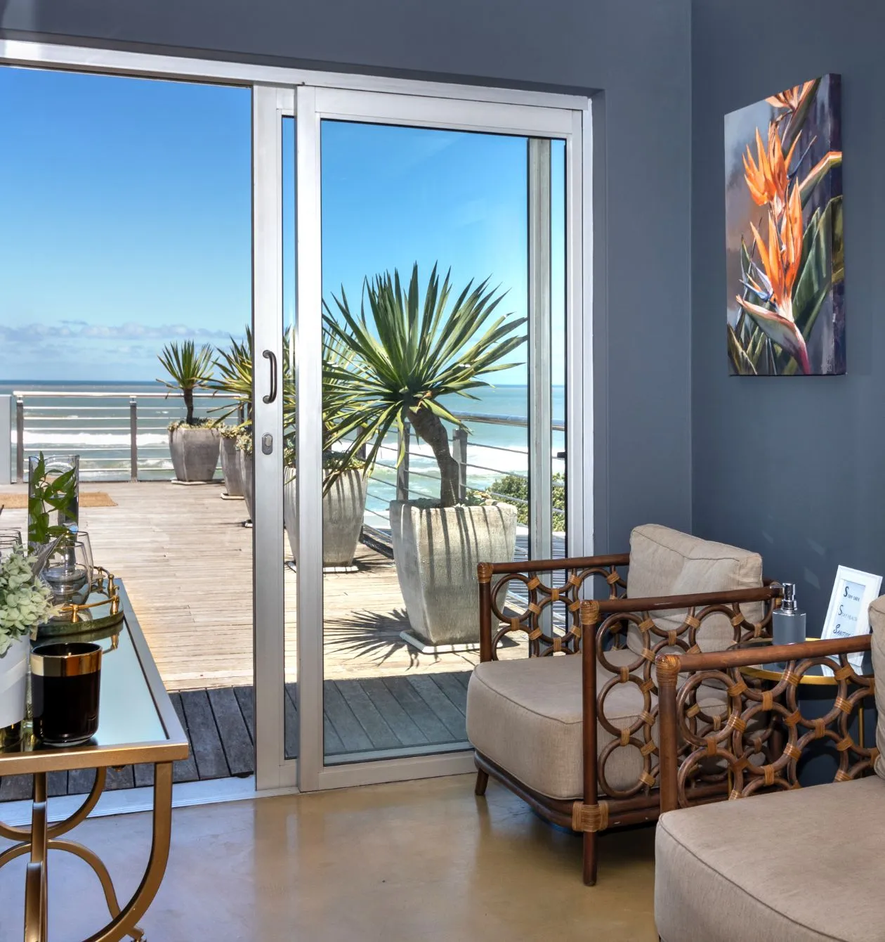Sliding door with ocean view potted plants and indoor seating area