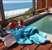 Beach view from deck with pool towel sunglasses and drinks