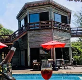 Wooden house with pool drink in foreground sunny day