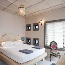 Cozy bedroom with a bed floral chair and decorative wall niches