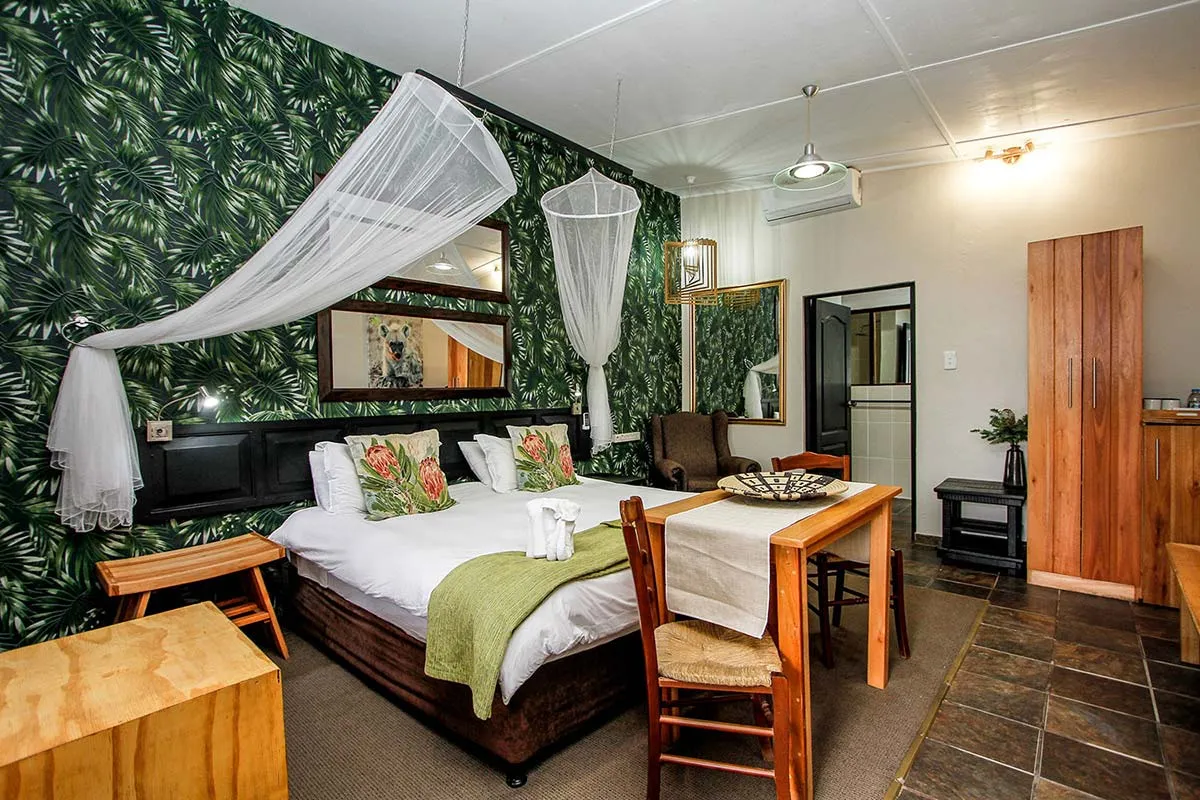 Cozy bedroom with a double bed wooden furniture and junglethemed wallpaper