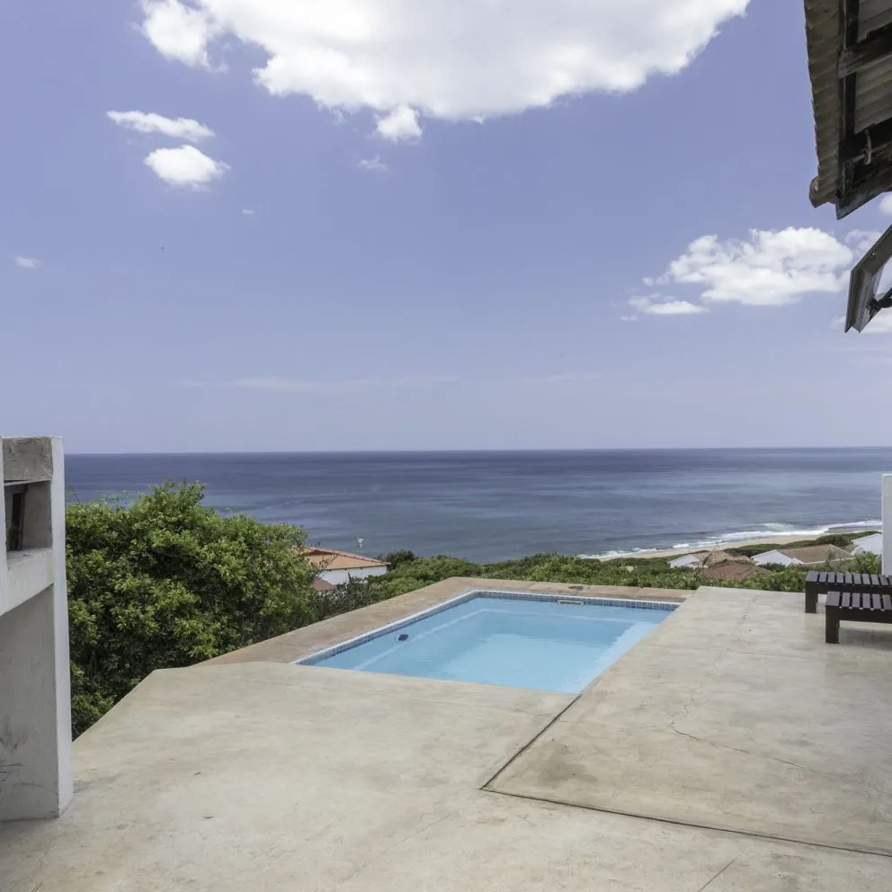 Swimming pool with ocean view blue sky and clouds