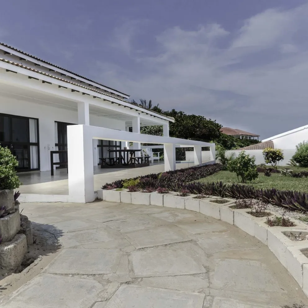 Modern white house with garden pathway and blue sky background