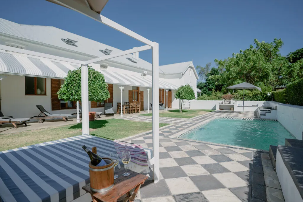 Modern backyard with pool lounge chairs and outdoor dining area