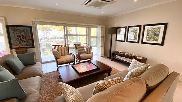 Cozy living room with sofas chairs and large windows overlooking a garden