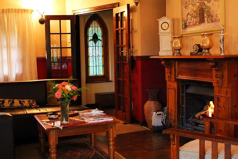 Cozy living room with fireplace floral arrangement and stained glass window