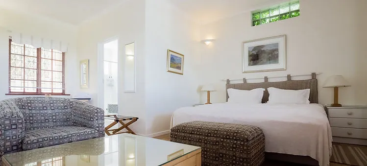 Bright bedroom with a large bed patterned sofa and modern decor