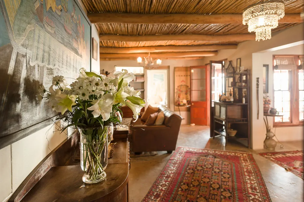 Vase of white flowers on a wooden table in a cozy rustic living room
