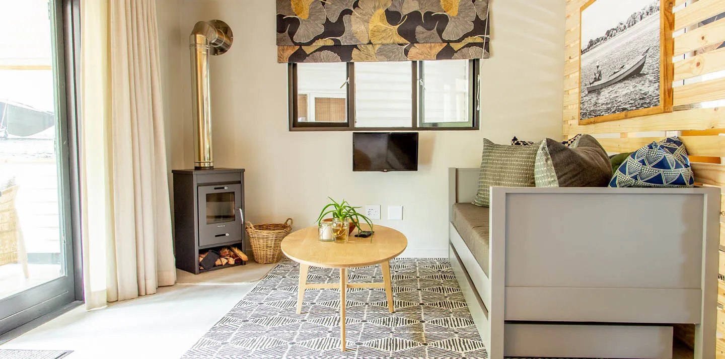 Cozy living room with sofa coffee table wood stove and window view