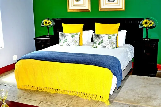 Brightly colored bedroom with a large bed yellow and blue bedding
