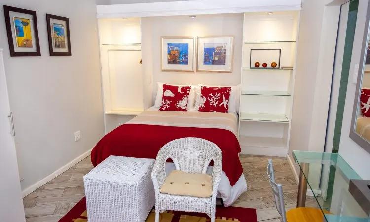 Cozy bedroom with red and white decor bed chair and wall shelves
