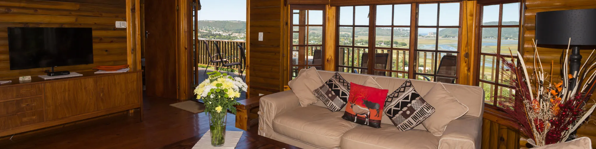 Cozy living room with sofa TV and large windows overlooking a scenic view