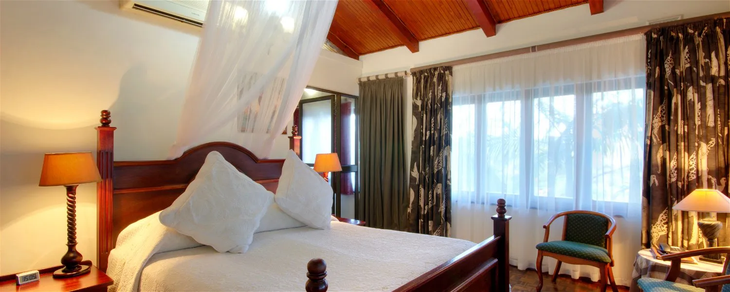 Cozy bedroom with a large bed wooden furniture and large windows