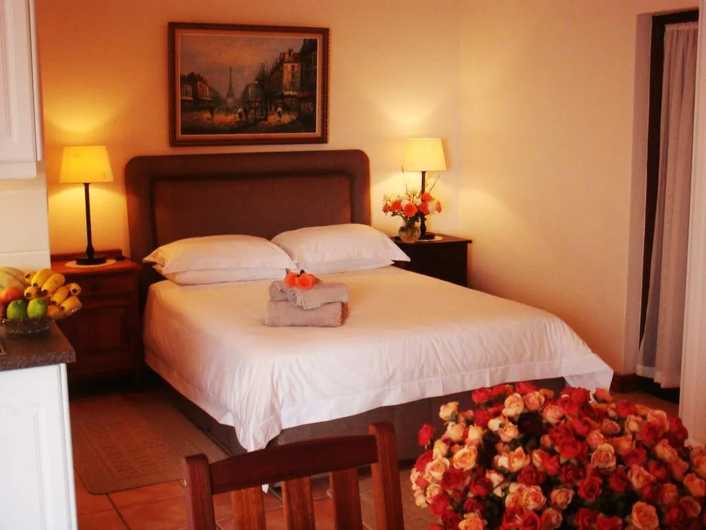 Cozy bedroom with a bed flowers and a painting above the headboard