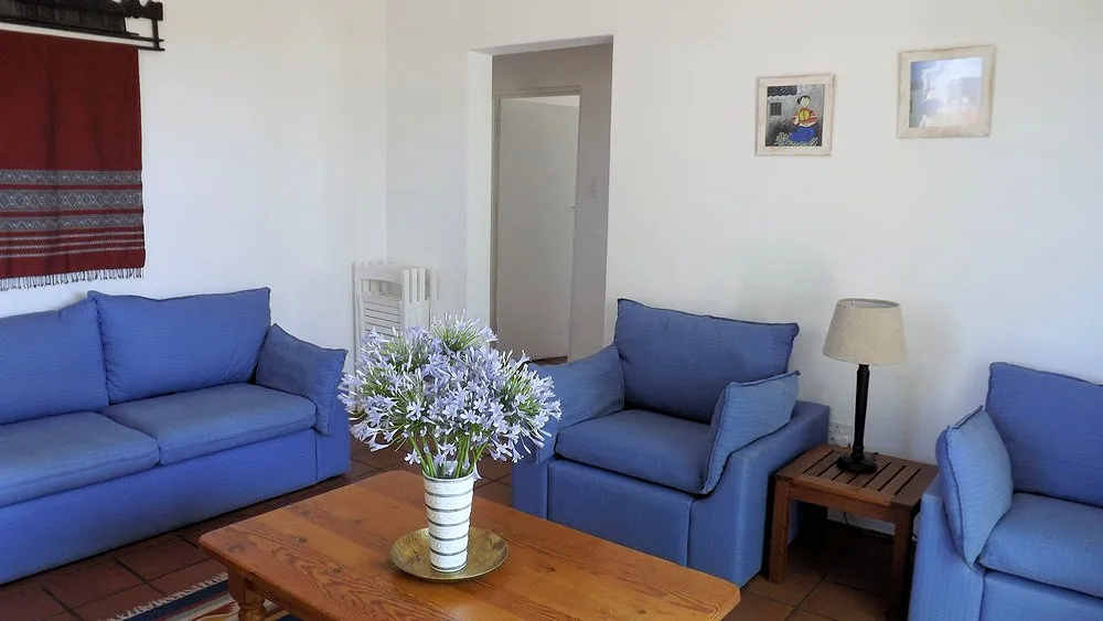 Blue living room with sofas a table flowers and wall art