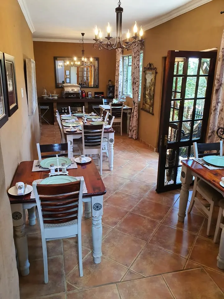 Dining room with tables chairs and a chandelier with a view of the garden