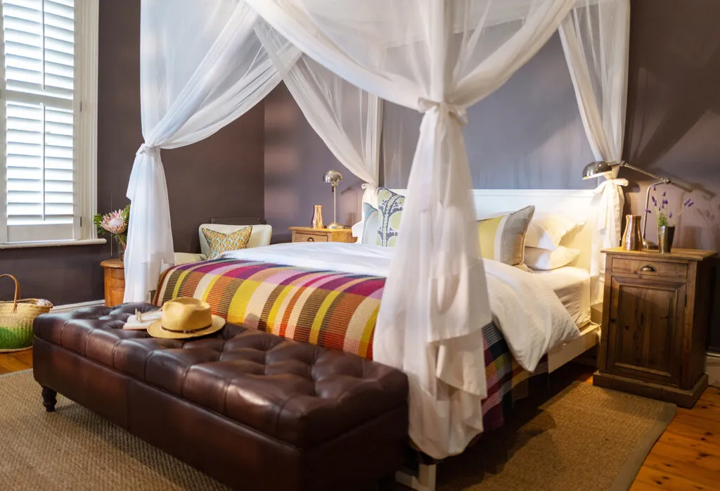 Cozy bedroom with a fourposter bed colorful blanket and bedside tables