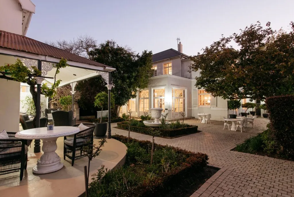 Evening view of a house with outdoor seating and garden