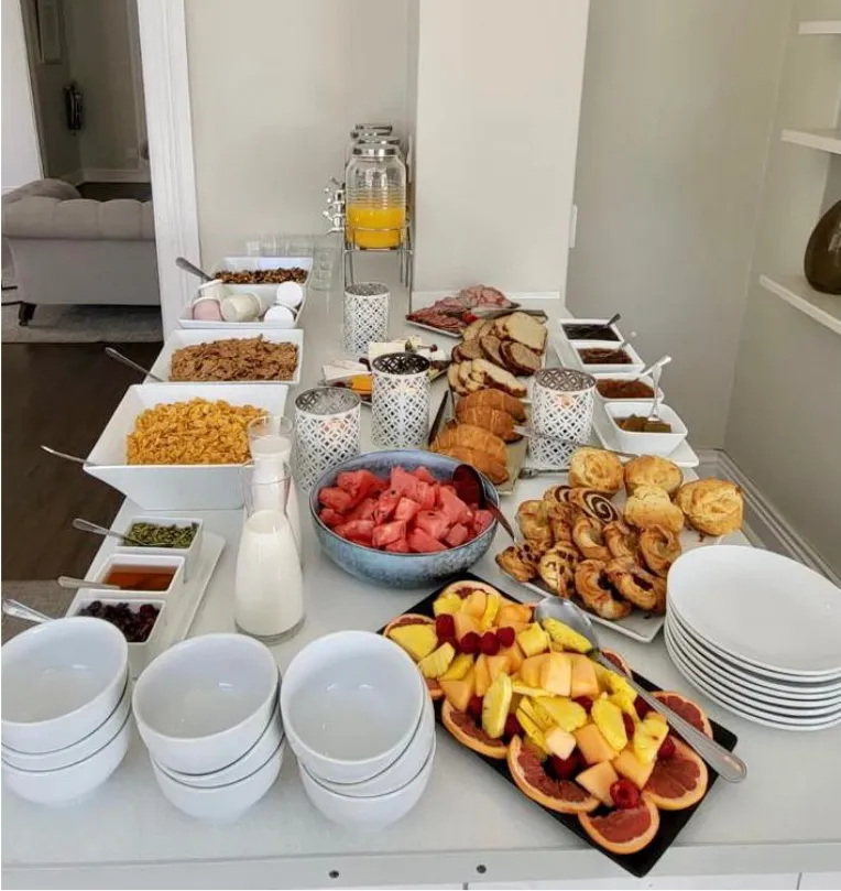 Buffet table with various breakfast foods including pastries fruits and cereals