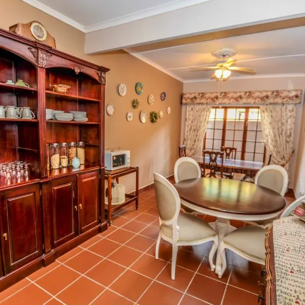 Wooden dining table with chairs in a cozy decorated room with tiled floor
