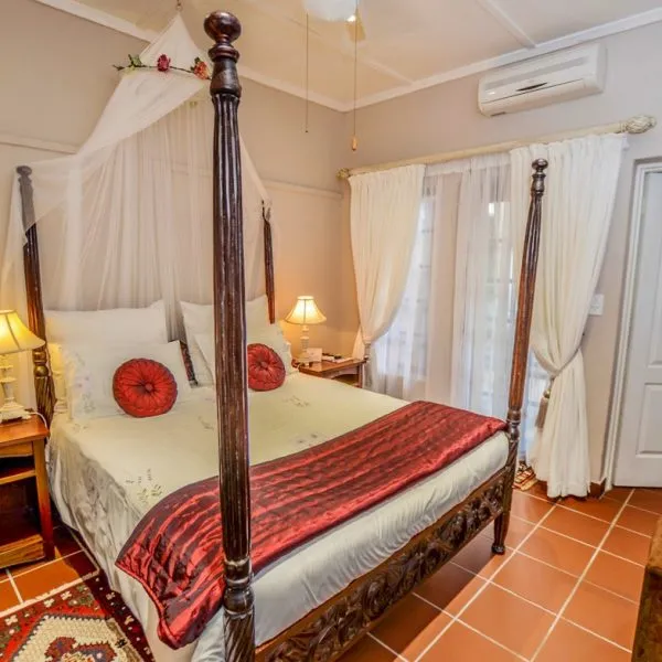 Fourposter bed with red and white bedding in a cozy bedroom